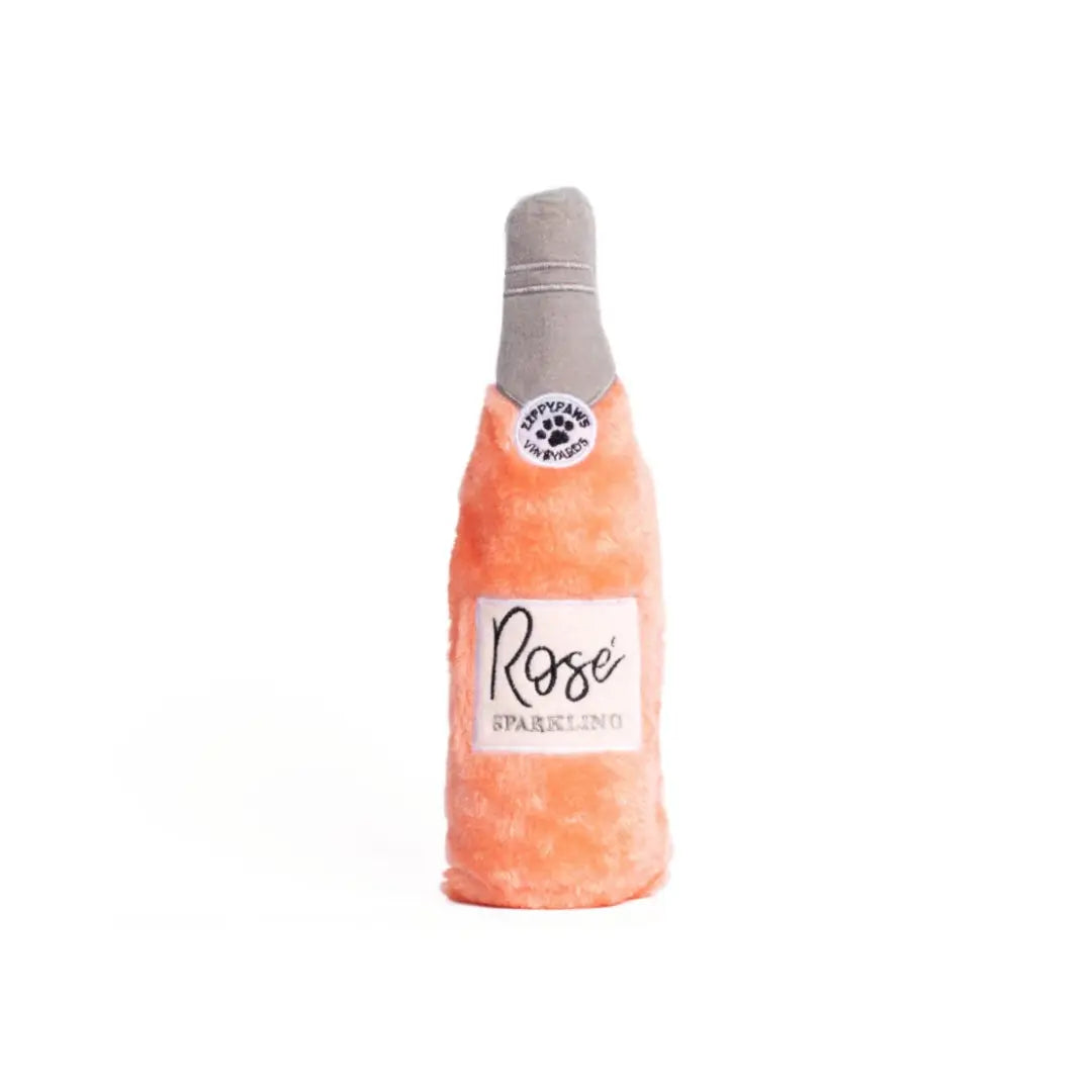 Dog toy shaped like a bottle of Rosé sparkling wine on a white background